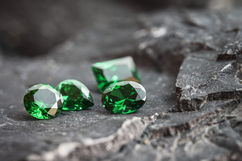 pedras preciosas de safiro verde natural brilhantes em uma superficie rochosa acidentada Grande